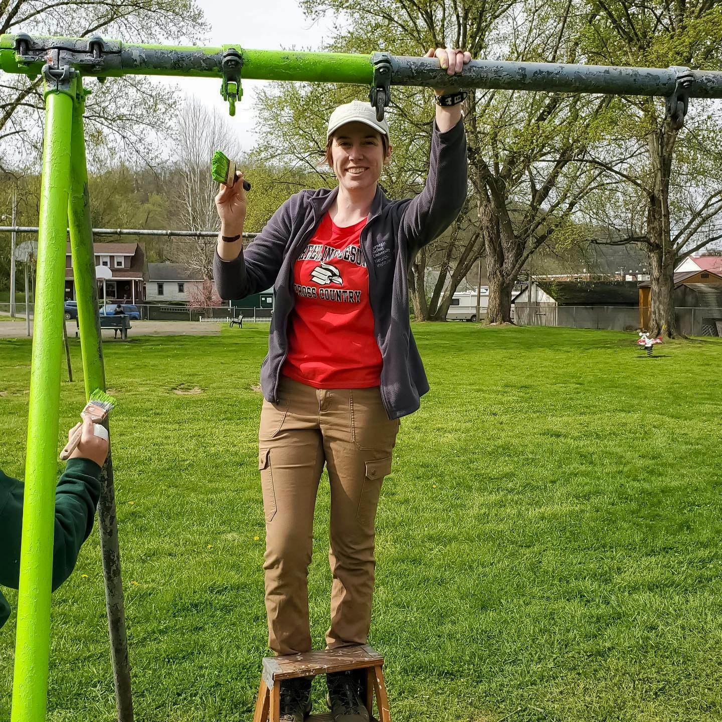 a picture of rachel volunteering, painting a swingset