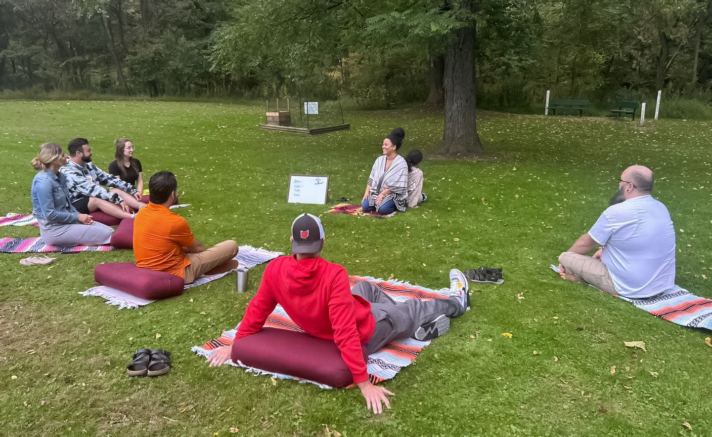 yopros sitting under a tree at a park